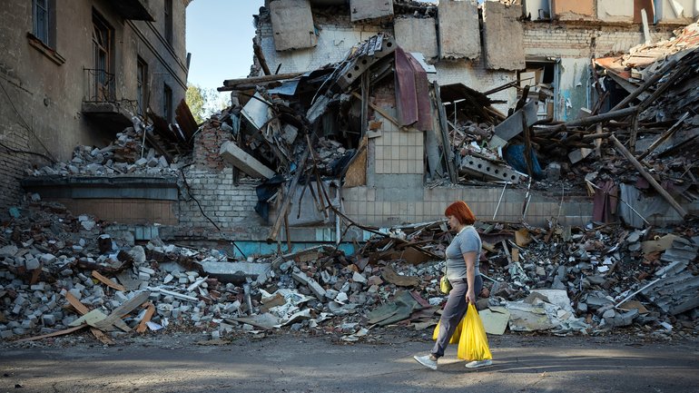 A woman walks past the wreckage of destroyed buildings in Sloviansk, in the Donbas region of Ukraine.