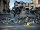 A woman walks past the wreckage of destroyed buildings in Sloviansk, in the Donbas region of Ukraine.