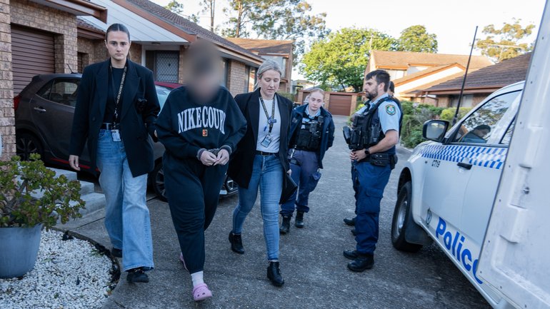 A woman has become the seventh person charged after police allegedly uncovered an elaborate plot to assassinate a prominent underworld figure.