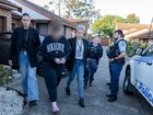 A woman has become the seventh person charged after police allegedly uncovered an elaborate plot to assassinate a prominent underworld figure.