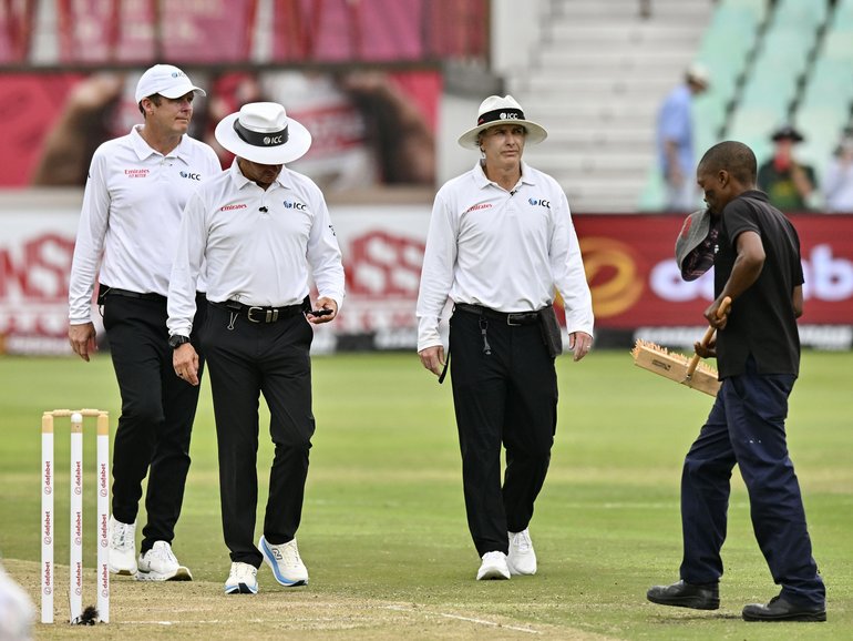 Umpires check the light during day 1.