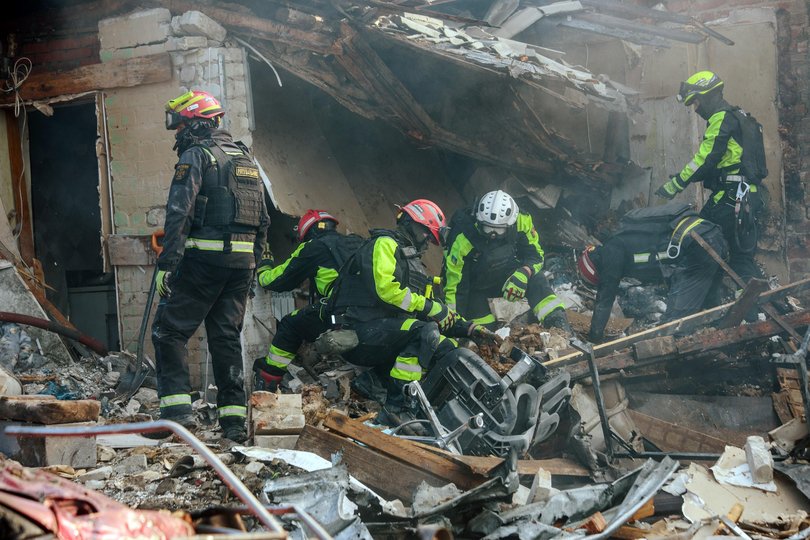 Rescuers work at the site of a Russian guided bomb (KAB) strike in Kharkiv, Ukraine, on October 11.
