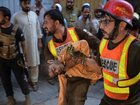 Rescuers carried bloodied children to waiting ambulances after a school roof collapsed in Pakistan. (AP PHOTO)