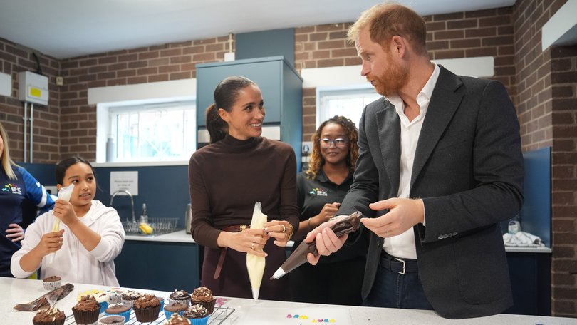 Meghan, Duchess of Sussex and Prince Harry, Duke of Sussex decorate cupcakes at Epic Partners.