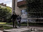 A man in a Ukrainian military uniform and a boy pass under protective netting.