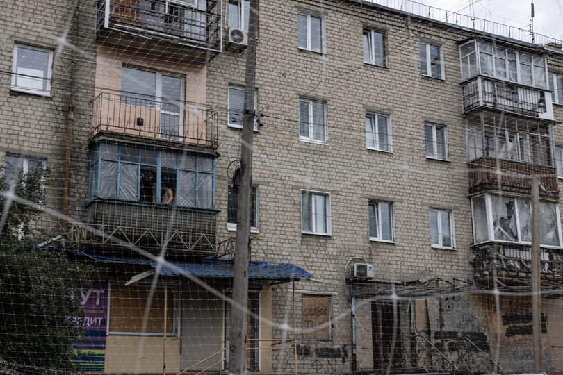 An apartment building in Izyum is lined in netting.