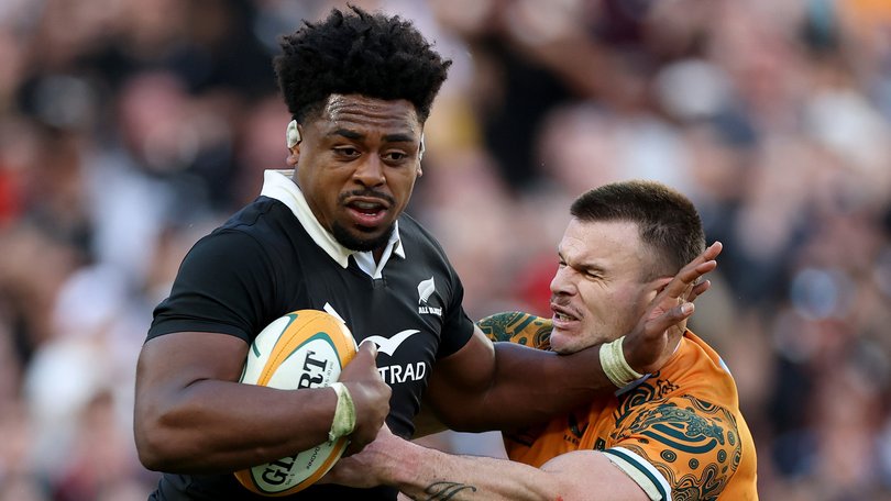 Peter Lakai of the All Blacks is tackled by Isaac Henry of the Wallabies.)
