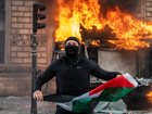 A protester holds a Palestinian flag as a bus stop burns during a demonstration at Place de Republique on October 17, 2026 in Paris, France. 