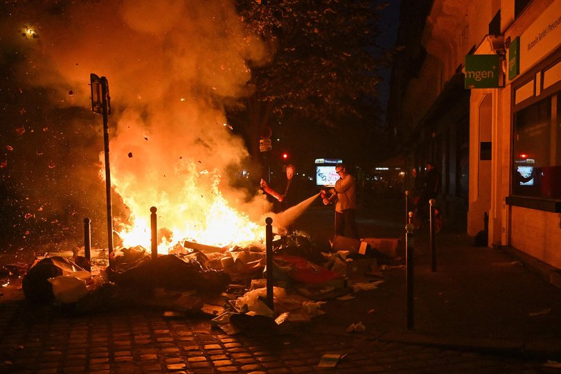 Inhabitants use a fire extinguisher on burning trashes near Oberkampf metro station at Place de la Republique.