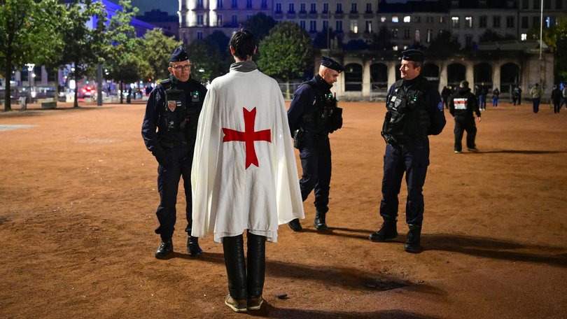 French police officers check a person during a partial curfew in Lyon.