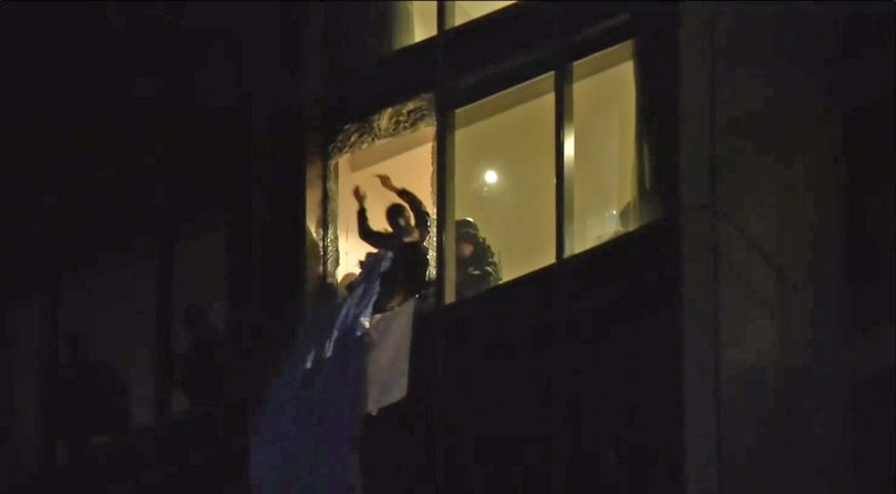Firefighters smashed a glass panel worth about $20,000 to reach the 22-year-old, who has since been charged with burglary.