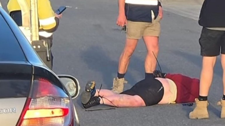 An axe-wielding man who caused an eight car pile up was cable-tied by tradies. 
