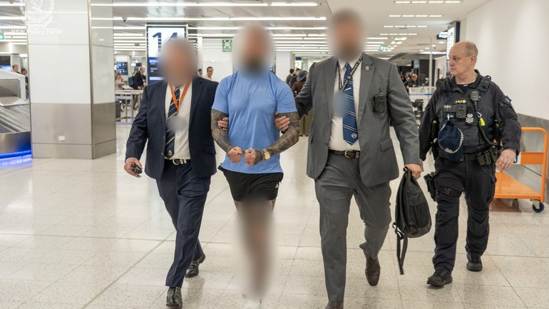 The alleged national enforcer of the Lone Wolf bikie gang was met by police at Sydney Airport after spending 20 months in Bali.