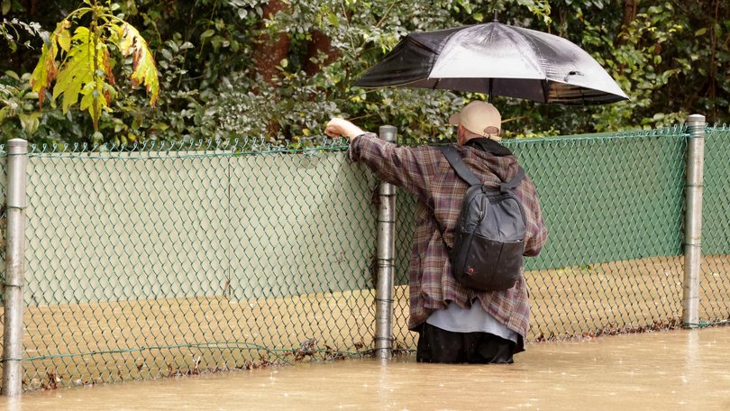A man checks on homeless people after heavy rain led to flash flooding near Caboolture. Picture: Steve Pohlner