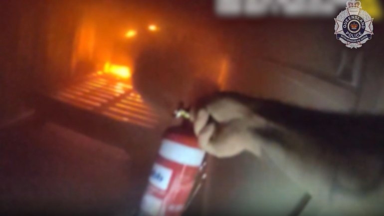 Dramatic footage shows police rushing into a smoke-filled Queensland home to rescue a woman.