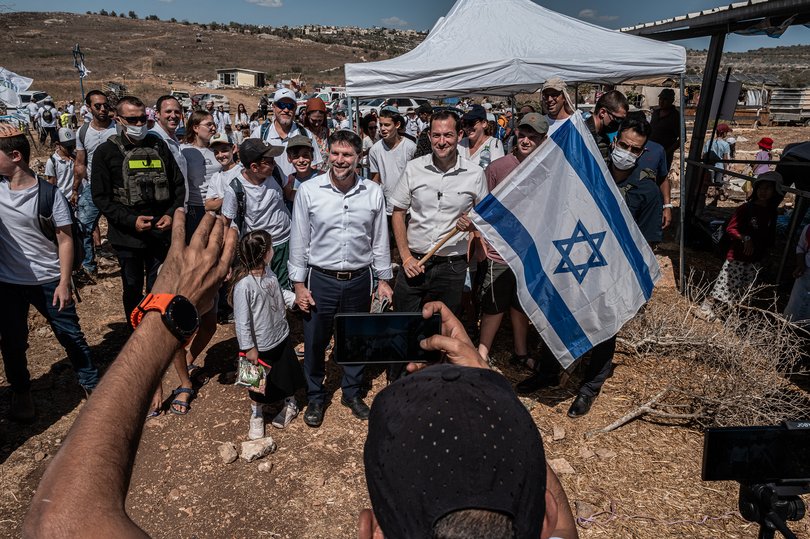 The Israeli finance minister, Bezalel Smotrich, centre left, with Jewish settlers in part of the West Bank, marking the holiday of Sukkot and 50 years of settlement in the area in October 2025.