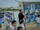 A Palestinian family walks past election campaign posters for Israel's National Security Minister and Otzma Yehudit party leader Itamar Ben Gvir on October 27, 2026 in Beit Kahil, West Bank. 