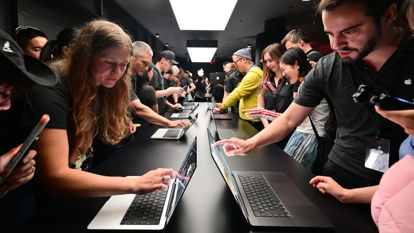 Attendees try out the new touchscreen MacBook Pro during the Apple Experience LA in Los Angeles, Oct. 28, 2026.