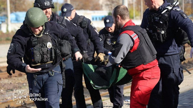 A paramedic and police officers carry a person injured at a railway station during a Russian drone strike, amid Russia's attack on Ukraine, in Dnipro.