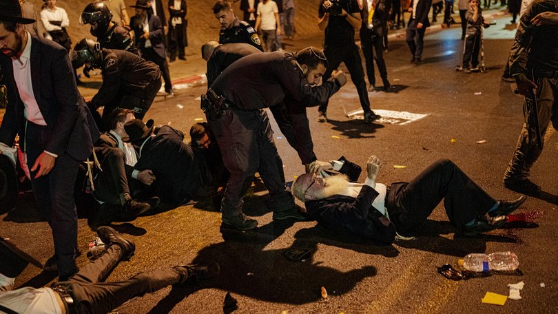 Ultra-Orthodox men scuffle with Israeli police officers during a protest over the military conscription of Haredi students during a protest over the military conscription. The issue had become a flashpoint in Israeli politics since a previous blanket exemption for yeshiva students expired.