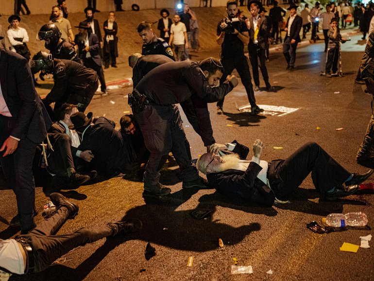 Ultra-Orthodox men scuffle with Israeli police officers during a protest over the military conscription of Haredi students during a protest over the military conscription. The issue had become a flashpoint in Israeli politics since a previous blanket exemption for yeshiva students expired.