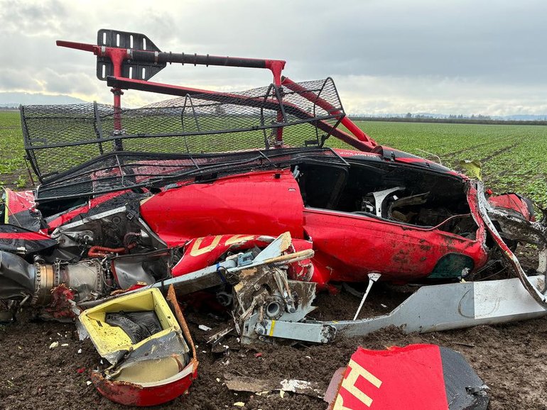 Authorities are examining the wreckage of two helicopters that collided near an airport in Oregon. (AP PHOTO)