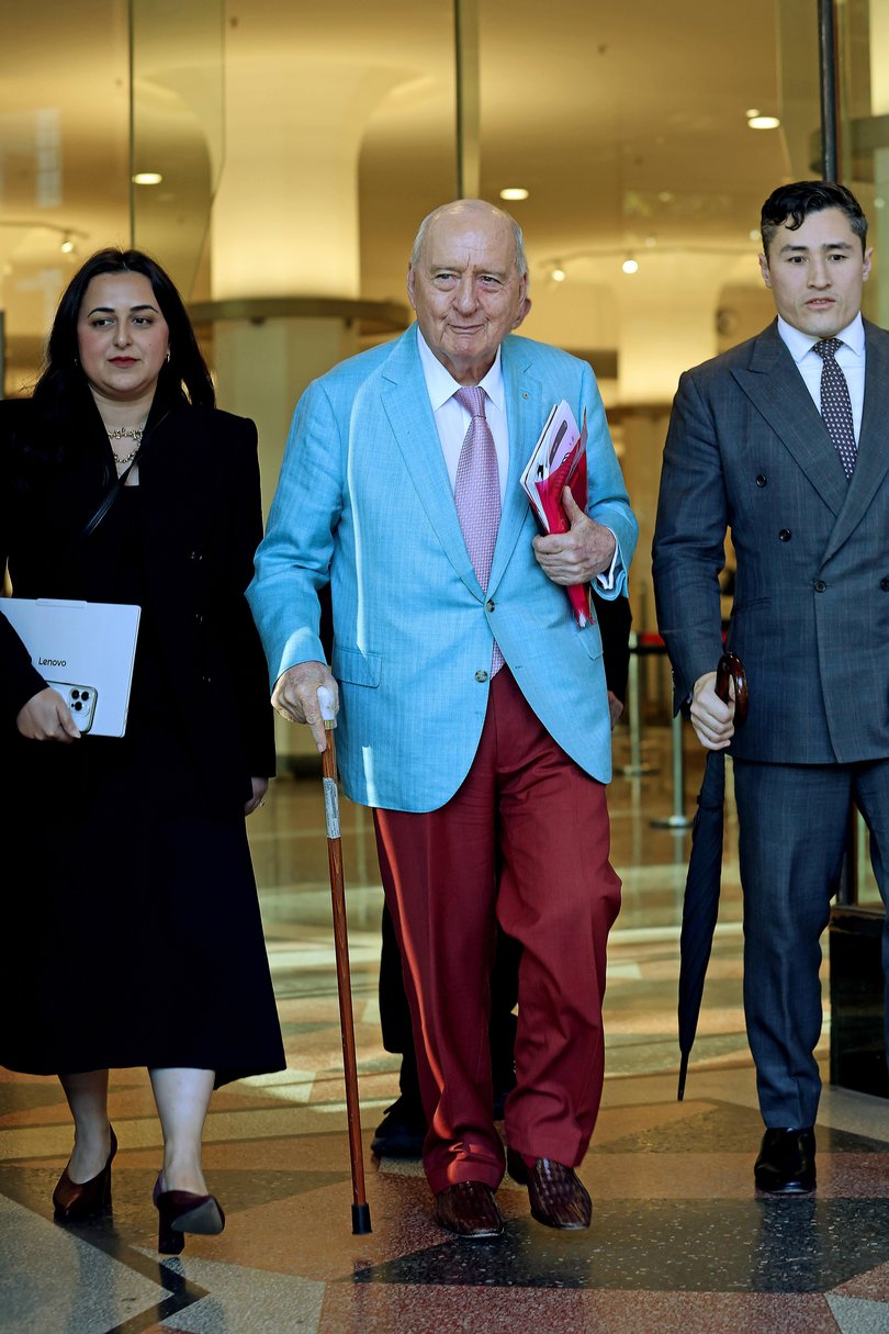 Alan Jones surrounded by his team.