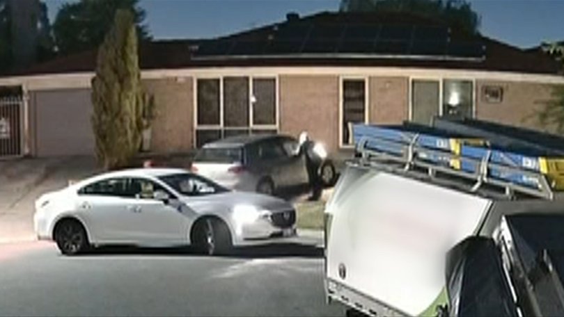 Two hooded figures appear to pour liquid on the car, before lighting it on fire.